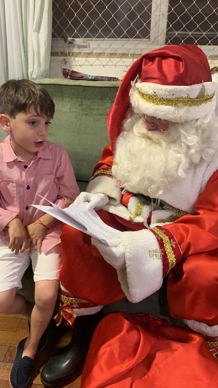 Papai Noel com criança, entrega de presentes